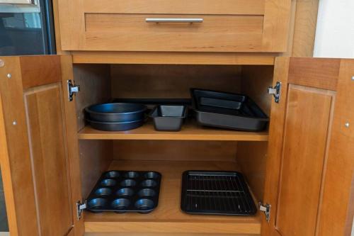 a cabinet filled with bowls and other food items at HAWAII PARADISE 3Bd2a Home w Pool and FirePit near Ocean in Keaau