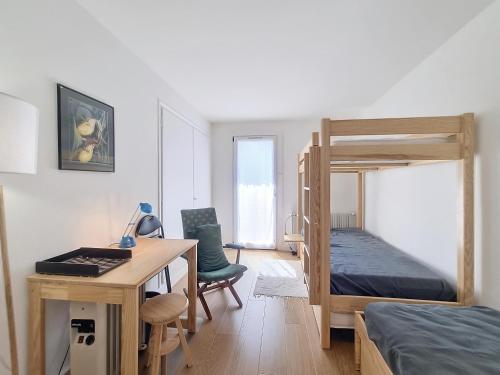 - une chambre avec un bureau et des lits superposés dans l'établissement Appartement 3 pièces avec balcon et parking à Combloux - FR-1-560-146, à Combloux