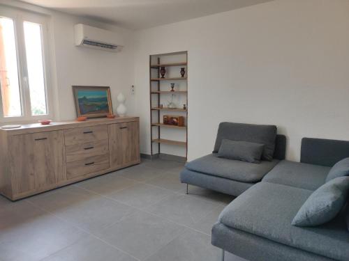 un salon avec deux chaises et un canapé dans l'établissement Appartement rénové avec clim, piscine, WiFi et parking à Palau-del-Vidre - FR-1-776-108, à Palau-del-Vidre