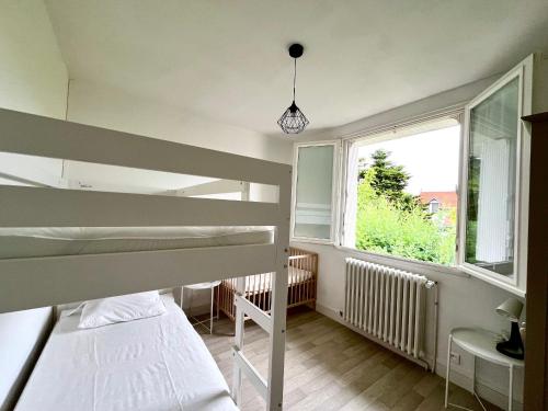 une chambre avec deux lits superposés et une fenêtre dans l'établissement Maison calme avec cour et terrasse proche Aiguillon - Parking - FR-1-319-578, à Arcachon
