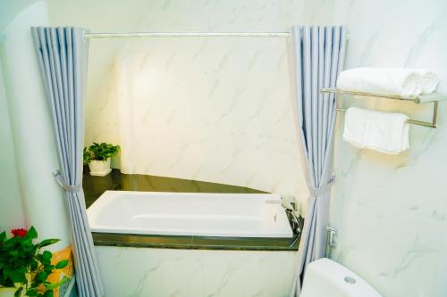 a bathroom with a bath tub in a shower at MEDDOM Park in Cao Phong