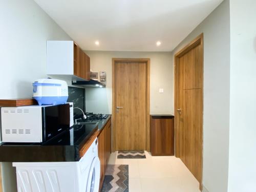 a kitchen with a counter top and a microwave at Comfort 1BR at Gateway Park LRT City Jatibening Apartment By Travelio in Bekasi