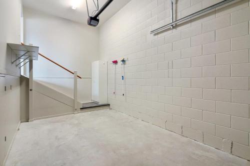 een lege kamer met witte muren en een trap bij Modern 2-Bedroom Oasis Just Steps from the Beach in Christchurch