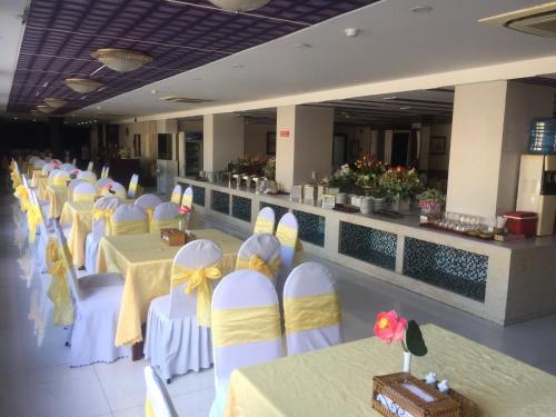 a banquet hall with tables and chairs with yellow and white bows at KHÁCH SẠN SAO MAI in Cao Lãnh