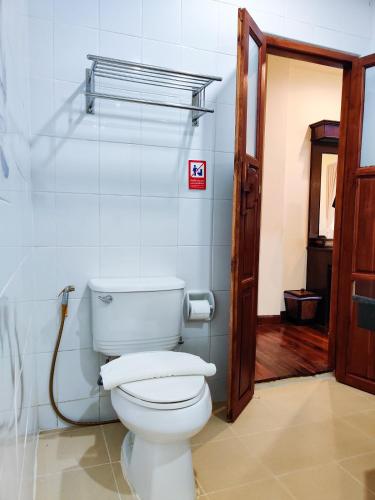 a bathroom with a white toilet in a room at อภิรตา รีสอร์ท in Nan