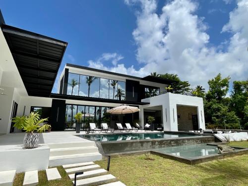 an exterior view of a house with a swimming pool at Casa B&W - Luxury Frente a Mar A 3 Minutos de la playa in Las Galeras