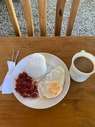 a plate of food with an egg and a cup of coffee at Free Breakfast Kabayod Place A1, General Luna Siargao in General Luna