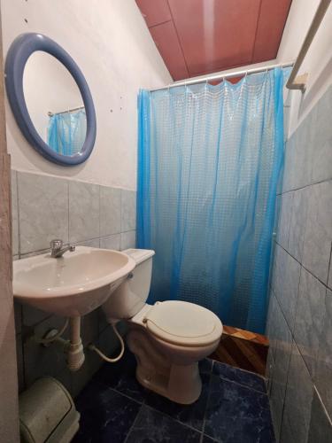 un bagno con un water, un lavandino e uno specchio di Sarisa House a Iquitos