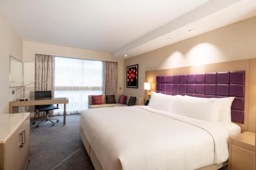 una camera d'albergo con un letto grande e una scrivania di Holiday Inn Golden Mile by IHG a Hong Kong