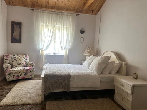 a bedroom with a bed and a chair and a window at 4154ft in ramboda in Ramboda