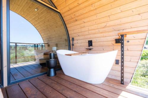a white bath tub sitting on a wooden deck at SWEET SONOMA SPYGLASS with Sauna in Sebastopol