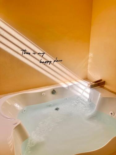 Una bañera con un cartel que dice "Ahí está mi lugar feliz". en Casa suite con Jacuzzi - Arenita Mia Suites, en Progreso