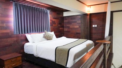 a bedroom with a bed with a brick wall at Alu Lofts in Seminyak