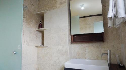 a bathroom with a sink and a mirror at Alu Lofts in Seminyak
