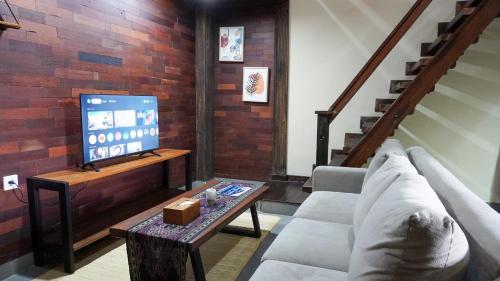 a living room with a couch and a tv at Alu Lofts in Seminyak