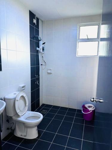 a bathroom with a toilet and a sink and a window at Sandakan Spacious and Comfortable Pool View Condo in Sandakan