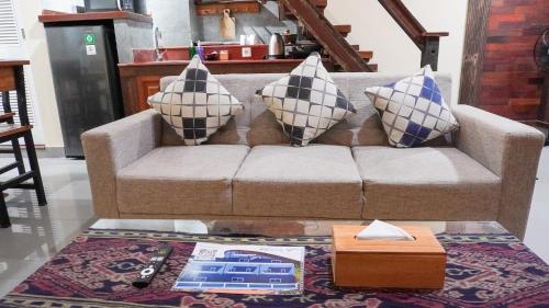 a living room with a couch with pillows on it at Alu Lofts in Seminyak