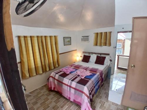 a hotel room with a bed and a window at Sandstorm Lodge and Cafe in Puerto Galera