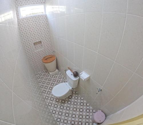 baño pequeño con aseo y suelo de baldosa. en Omah Prambanan Syariah, en Prambanan