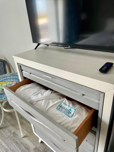 a tv sitting on top of a dresser at Ocean Sands Beach Boutique Inn-1 Acre Private Beach-St Augustine Historic-2 Miles-Shuttle with Downtown Tour-HEATED Salt Water Pool until 420AM-Popcorn-Cookies-New 4k USD Black Beds- 69 Item Breakfast-Eggs-Bacon-Starbucks- Free Laundry- #904-799-SAND in Saint Augustine