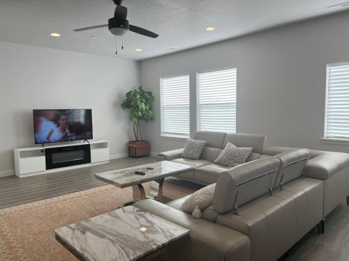 a living room with a couch and a tv at Modern Town House, 3-Bedrooms Home private parking in Draper
