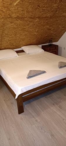 a bed with white sheets and a keyboard on it at Pyramid Holiday House in Visoko