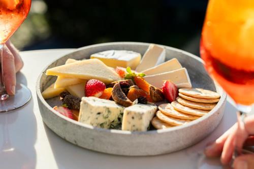 a bowl of cheese and crackers and fruit and a glass of wine at The Sebel Kiama in Kiama
