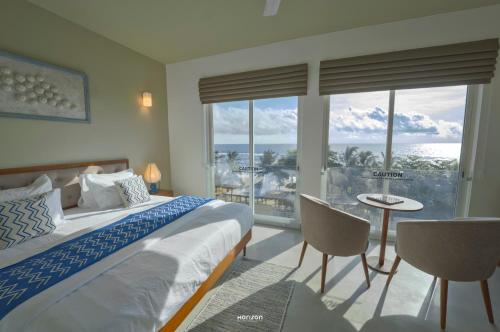 a bedroom with a bed and a view of the ocean at 50 By The Sea in Dehiwala