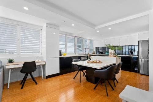 a kitchen with a table and chairs in a kitchen at Absolute Beachfront Apartment 3B Pool Spa in Gold Coast