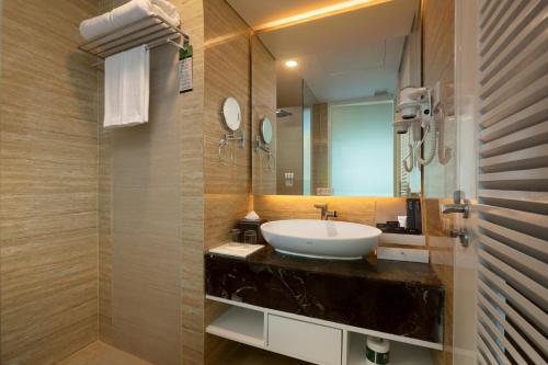 a bathroom with a sink and a mirror at Wyndham Panbil Batam in Batam Center