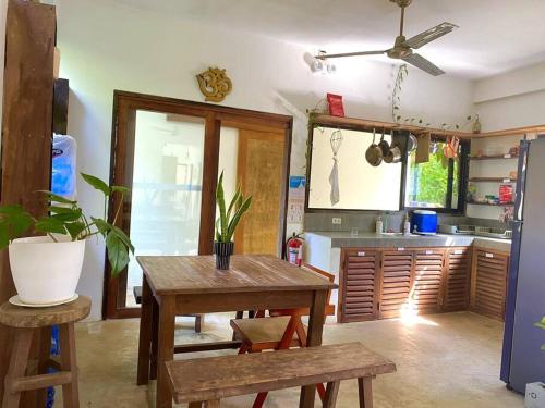 a kitchen with a wooden table and a dining room at Secret Spot Siargao in General Luna