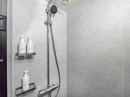 a shower with three bottles of soap in a bathroom at Oriental Hotel Tokyo Bay in Urayasu