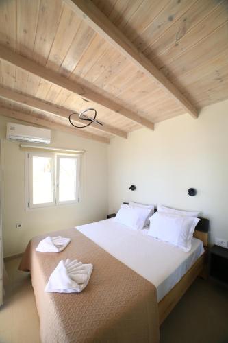 a bedroom with a large bed with two towels on it at GREEN n' BLUE apartments in Kalamaki