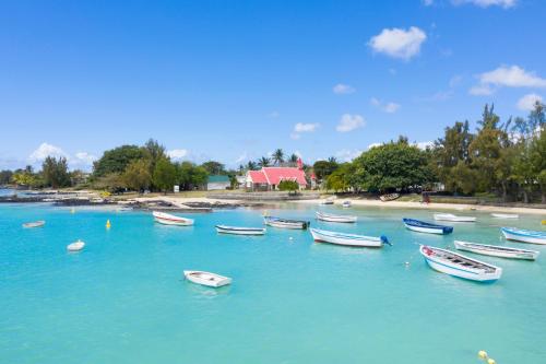 a group of boats in the water near a beach at Villa Cap Malheureux in Cap Malheureux