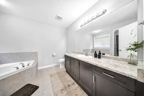 a bathroom with a tub and a sink and a bath tub at Lavish Home on Hamilton Mountain in Hamilton