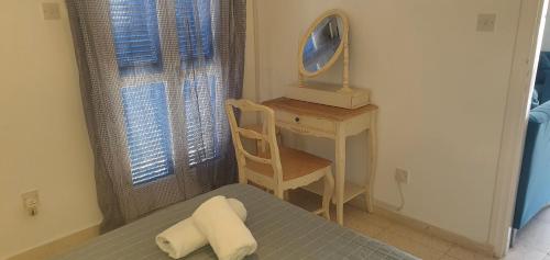 a bedroom with a bed and a desk and a tv at G&E Latchi Harbour View in Lachi