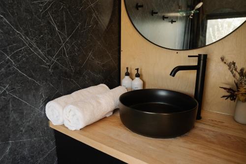 un baño con lavabo negro y toallas en una encimera en Bon the Tiny Cabin in Yallingup, en Yallingup