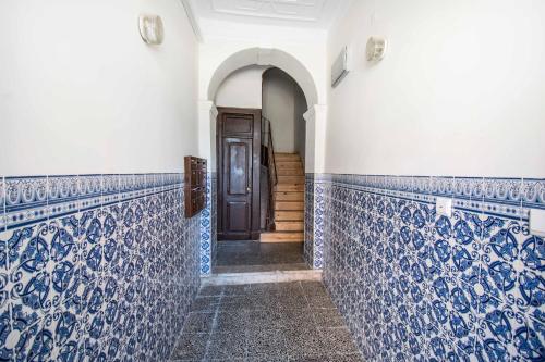 a hallway with blue and white tiled walls and a door at Lisbon Guesthouse in Lisbon