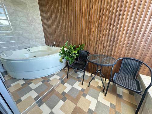 a bathroom with a tub and a table and chairs at Jingle Bells Resort in Ko Larn