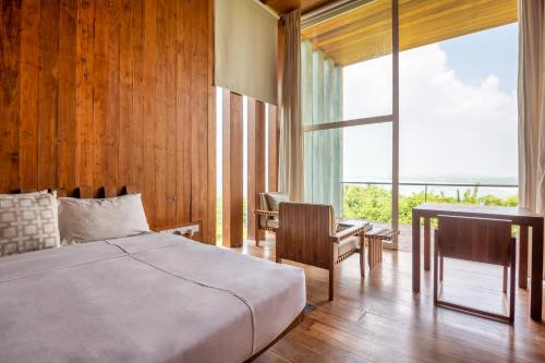 a bedroom with a bed and a desk and a window at Villa Vista by The Serendipity Collection in Mirissa