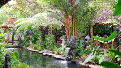 a garden with a pond with a fountain in it at Ubud Art Resort in Ubud
