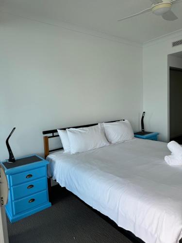 a bedroom with two beds and a blue nightstand at Harbour Quays Apartments in Gold Coast