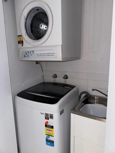 a small kitchen with a microwave above a sink at Harbour Quays Apartments in Gold Coast
