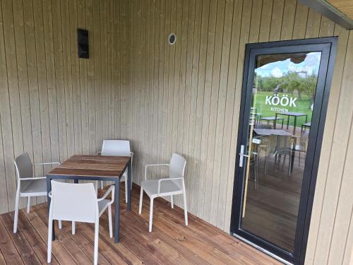 a table and chairs and a table and a door at Vetsi Talli Holiday Village in Kassari