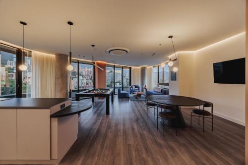a living room with two tables and a tv at Nock - Reserved Residences in Medellín