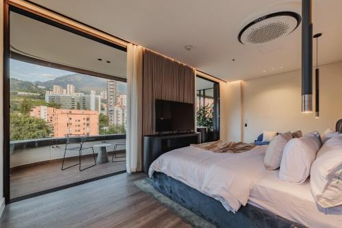 a bedroom with a large bed and a large window at Nock - Reserved Residences in Medellín