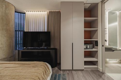 a bedroom with a bed and a tv in a room at Nock - Reserved Residences in Medellín