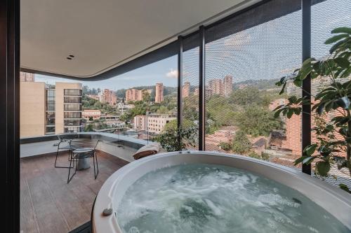 a bath tub in a room with a view of a city at Nock - Reserved Residences in Medellín