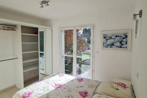 une chambre blanche avec un lit et une fenêtre dans l'établissement La maison de la plage pied dans l eau, à La Ciotat