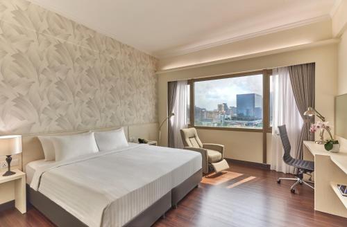 a hotel room with a bed and a window at Village Hotel Bugis by Far East Hospitality in Singapore
